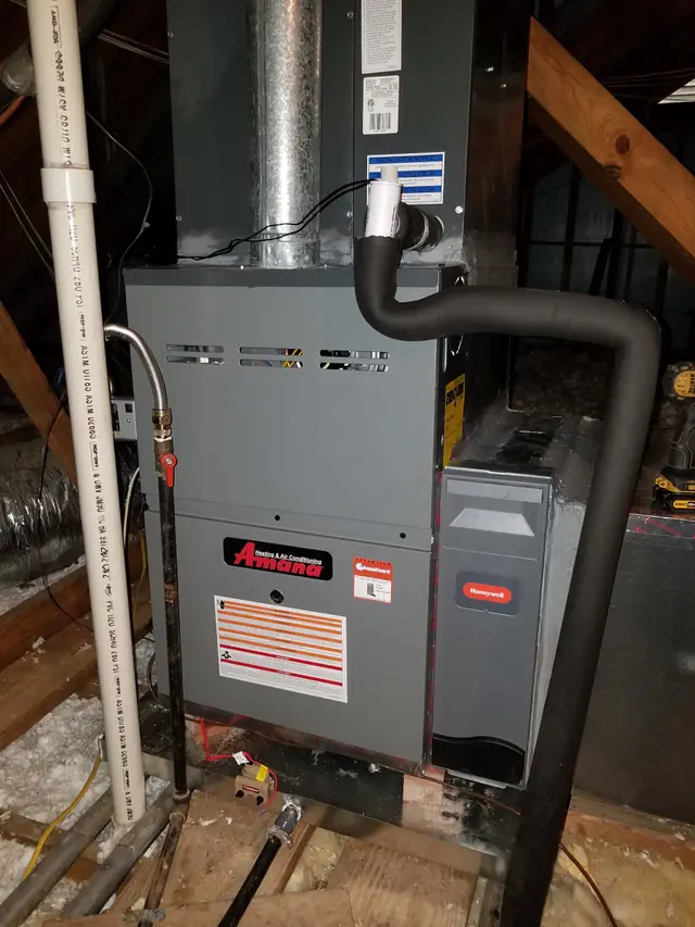 Amana furnace installed in an attic with a Honeywell media filter cabinet, float switch and gas shutoff